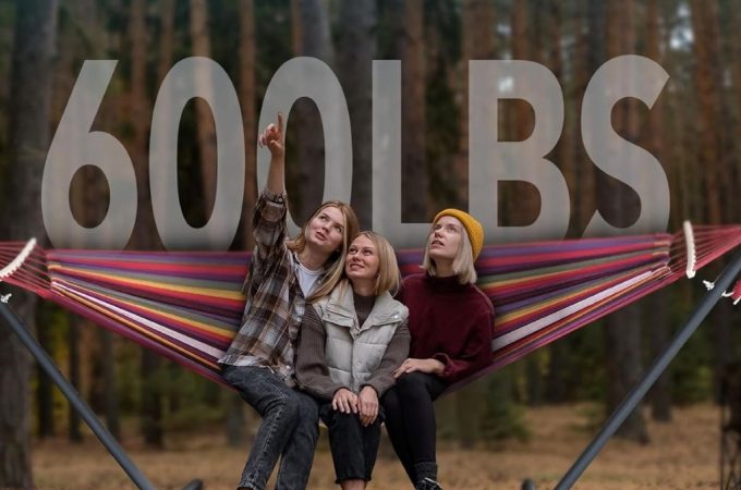 Cozy double hammock setup with steel stand in backyard—portable comfort solution for relaxing solo or with a partner.