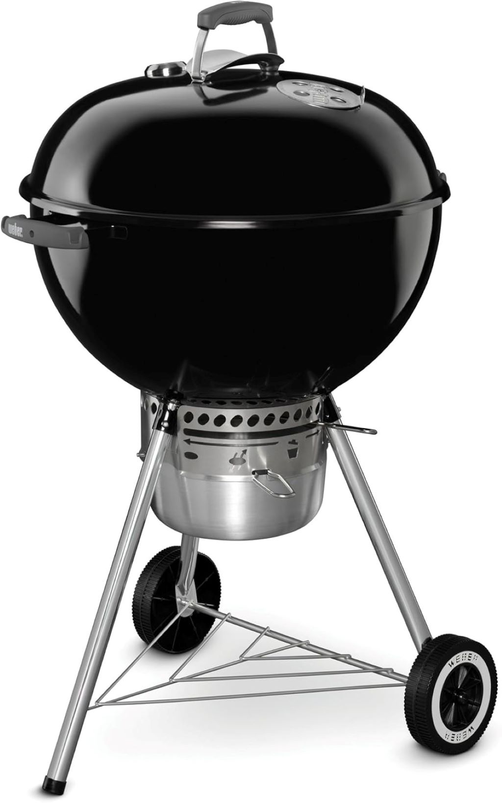 Weber 22″ kettle grill in action on a patio, with glowing charcoal and burgers sizzling on the grate.