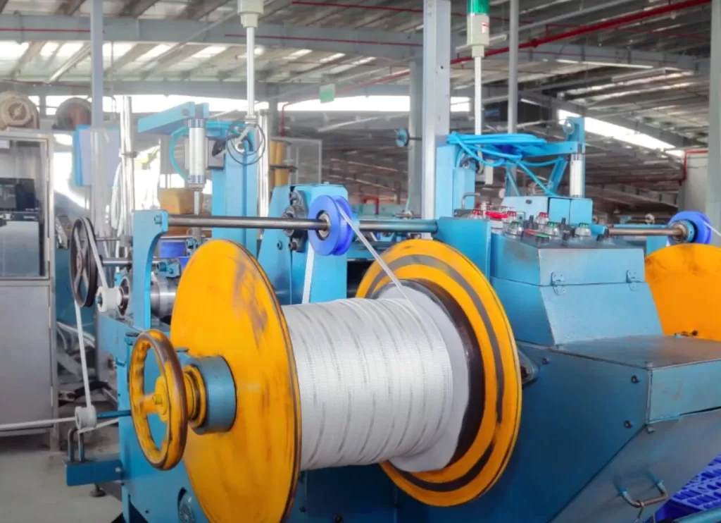 White polyester mule tape being pulled through a PVC conduit for cable installation