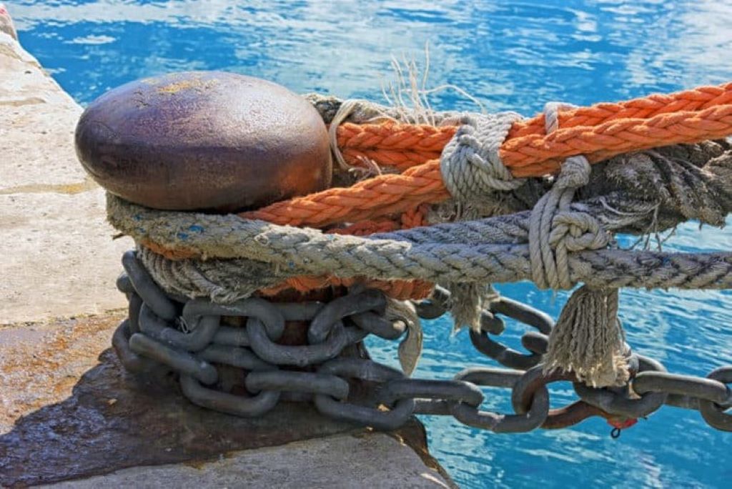 Close-up of thick marine ropes tied to a ship’s anchor point, highlighting their engineering precision and reliability