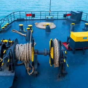 A large cargo ship securely moored to a dock with thick marine ropes demonstrating the strength and reliability of ship ropes