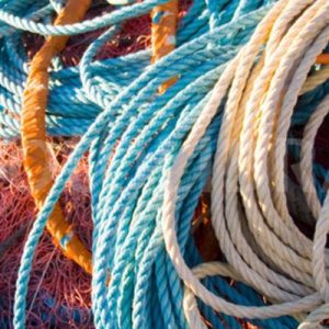 Fisherman inspecting fishing ropes on a dock to ensure strength and reliability.