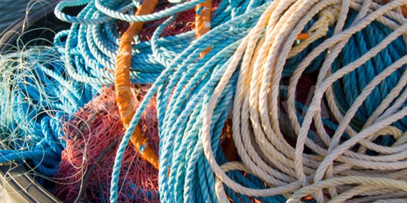 Fisherman inspecting fishing ropes on a dock to ensure strength and reliability.