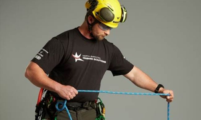 Fisherman cleaning and coiling a rope to keep it ready for daily use.
