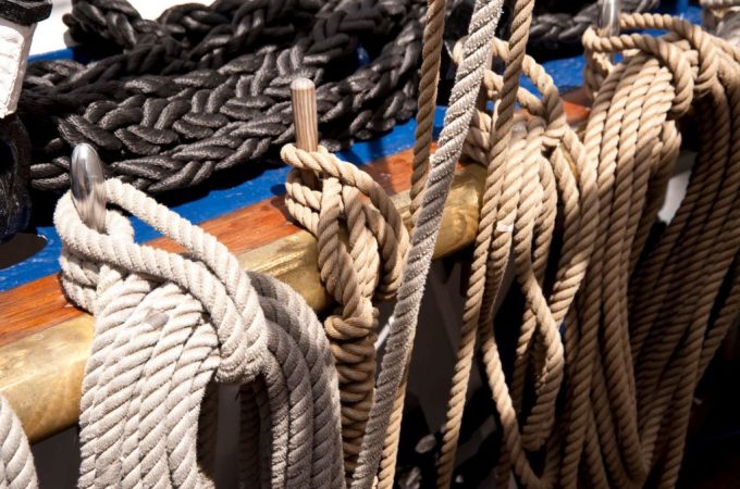 Close-up of a sailor inspecting and caring for strong, durable ropes.