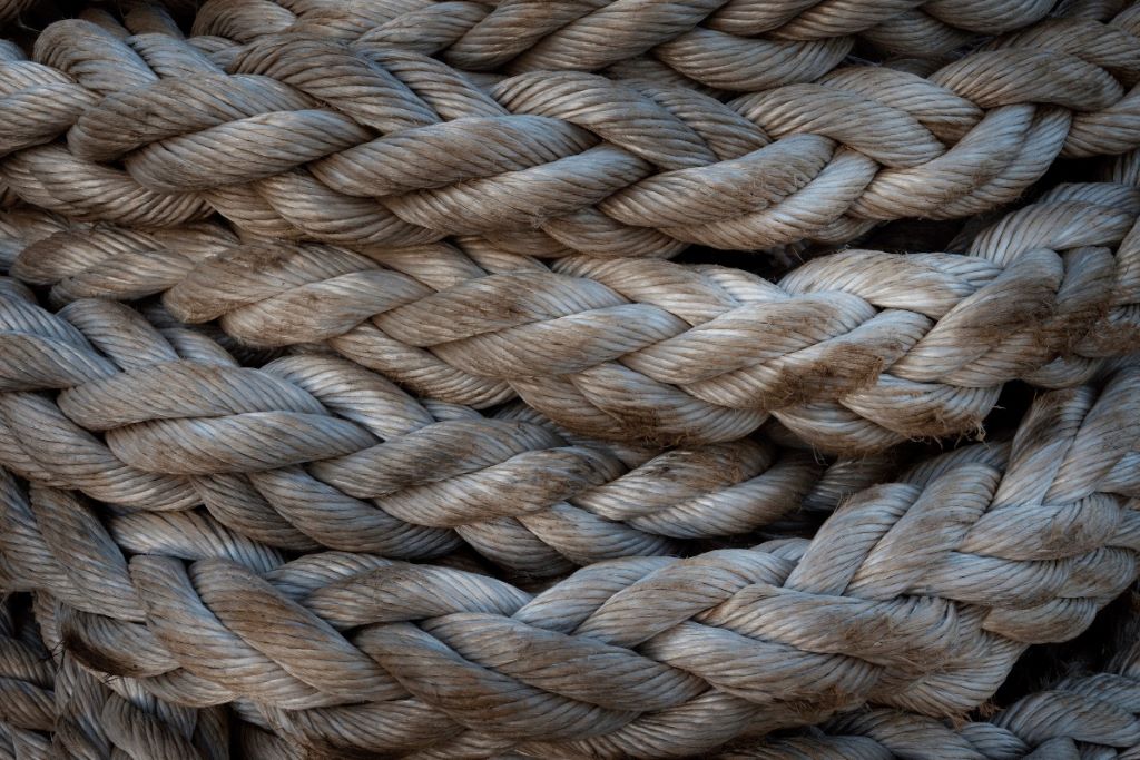 Well-maintained ropes coiled neatly on a ship deck, ready for use.