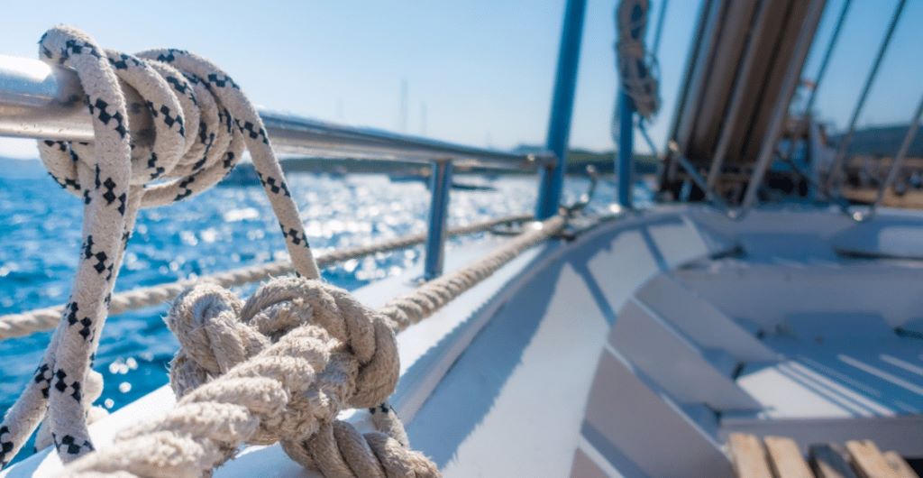 Seafarer examining a damaged rope affected by marine environmental factors.