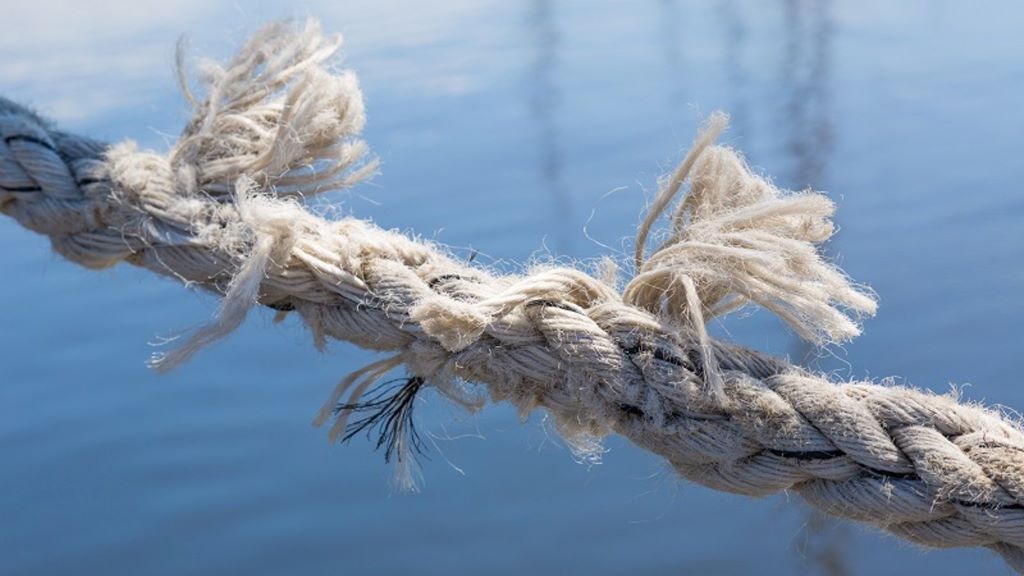 Hands coiling and maintaining a marine rope on deck.