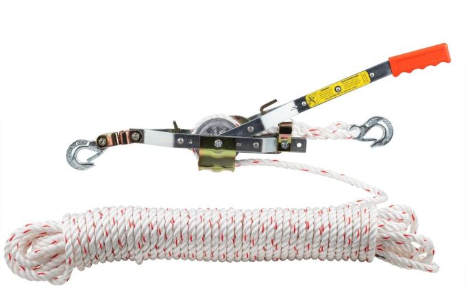 Worker inspecting and maintaining a heavy-duty rope used for pulling tasks.