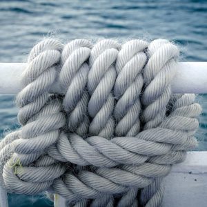 Well-maintained nautical rope coiled neatly on a ship deck.