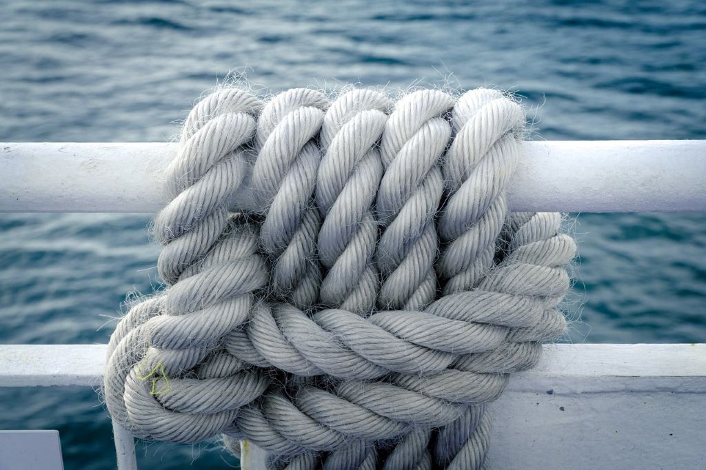 Well-maintained nautical rope coiled neatly on a ship deck.