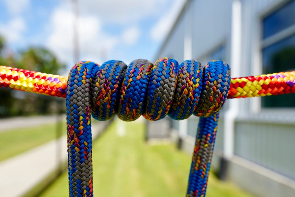 Mountaineering rope setup anchored on cliff for climbing safety and strength.