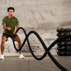 Person performing alternating wave battle rope workout for fitness and endurance