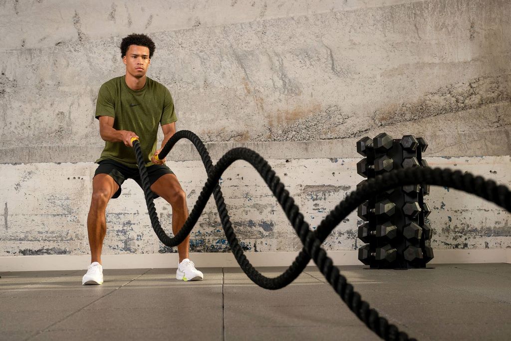 Person performing alternating wave battle rope workout for fitness and endurance