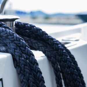 Boater selecting strong rope for boat anchor setup on a dock before sailing