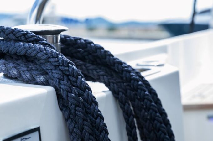 Boater selecting strong rope for boat anchor setup on a dock before sailing