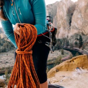 Climber cleaning outdoor climbing ropes to maintain safety and extend rope lifespan