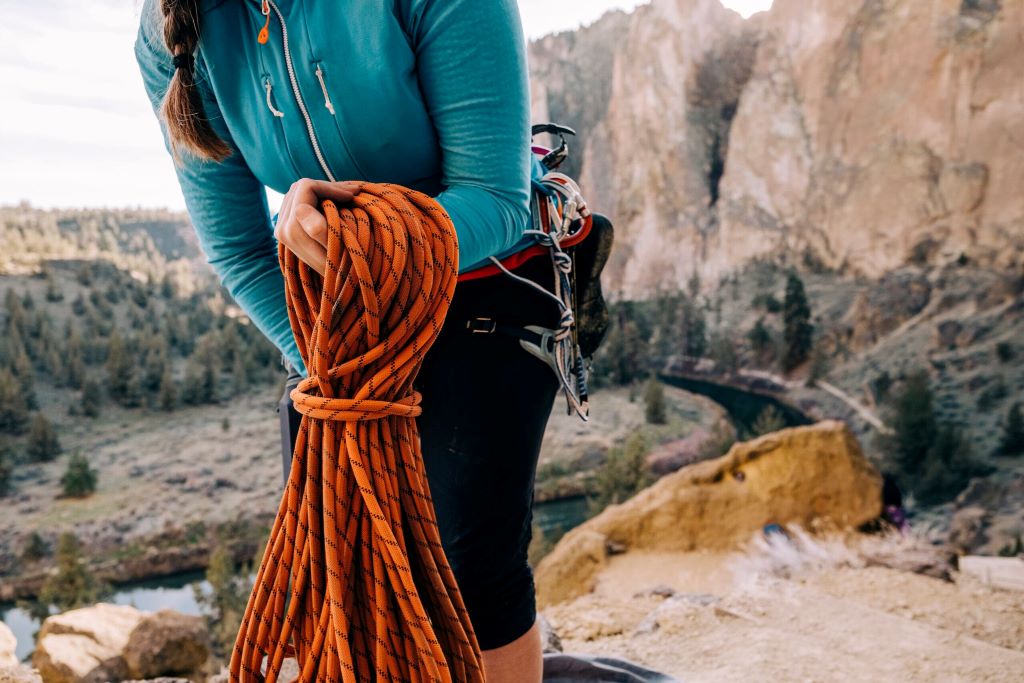 Climber cleaning outdoor climbing ropes to maintain safety and extend rope lifespan