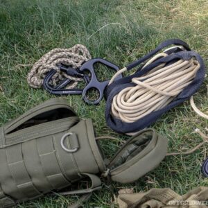 Camper using a multi-purpose rope to secure a tent during an outdoor camping trip