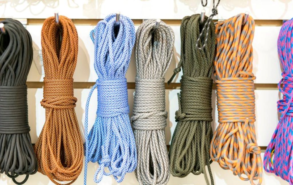 Multi-purpose survival rope tied between trees for camping and outdoor shelter setup